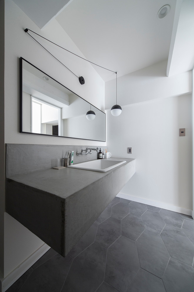 Inspiration för mellanstora industriella grått toaletter, med öppna hyllor, vita väggar, vinylgolv, ett undermonterad handfat, bänkskiva i betong och grått golv