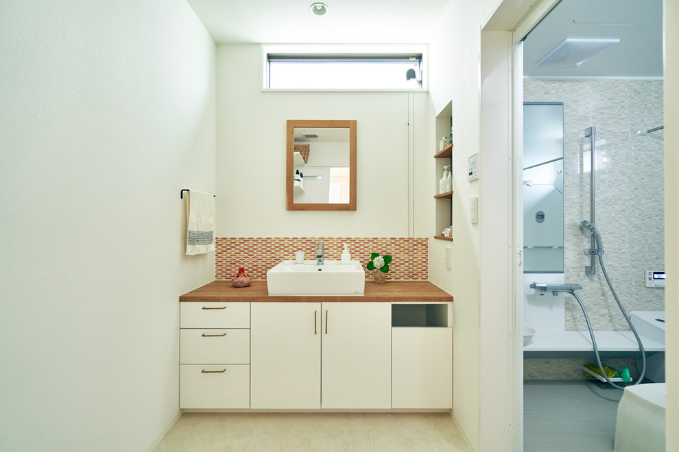 Modelo de aseo asiático con armarios con paneles lisos, puertas de armario blancas, paredes blancas, lavabo sobreencimera y suelo beige
