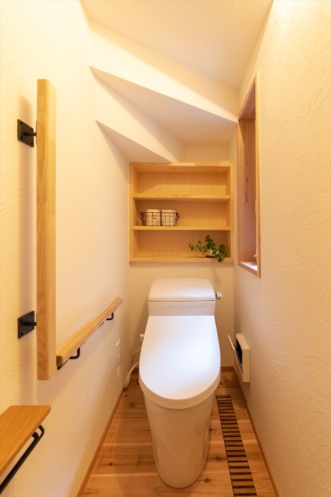 Esempio di un bagno di servizio nordico con pareti bianche, pavimento in legno massello medio e pavimento marrone