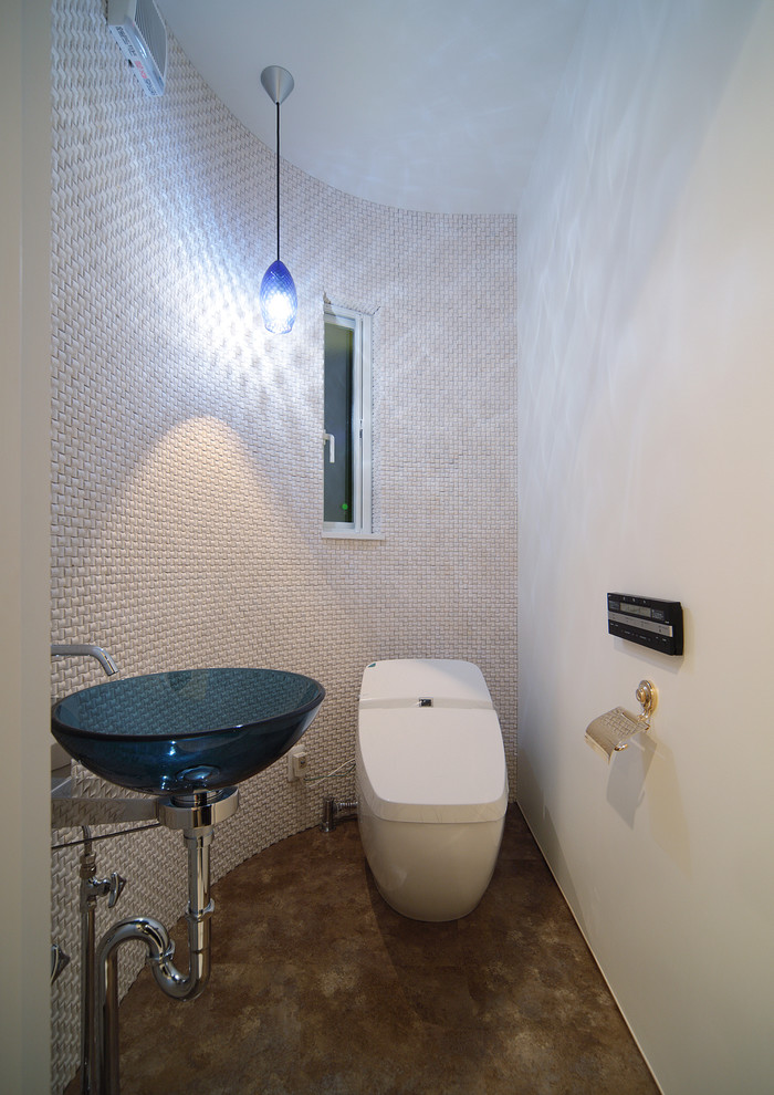 Foto di un bagno di servizio minimal di medie dimensioni con WC monopezzo, pareti beige, pavimento marrone, lavabo a bacinella, piastrelle beige, piastrelle in gres porcellanato e pavimento in vinile