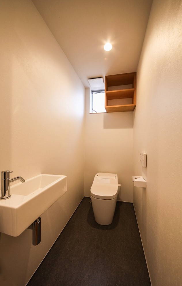 他の地域にある小さなアジアンスタイルのおしゃれなトイレ・洗面所 (白い壁、壁付け型シンク、グレーの床) の写真