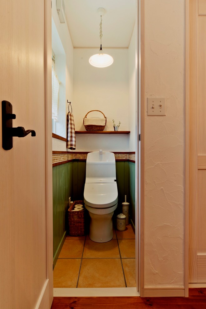 Пример оригинального дизайна: маленький туалет в средиземноморском стиле с полом из терракотовой плитки и коричневым полом для на участке и в саду