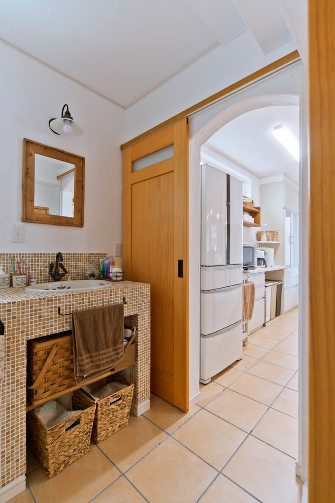 Источник вдохновения для домашнего уюта: туалет в средиземноморском стиле с открытыми фасадами, белыми стенами, полом из терракотовой плитки, накладной раковиной и коричневым полом