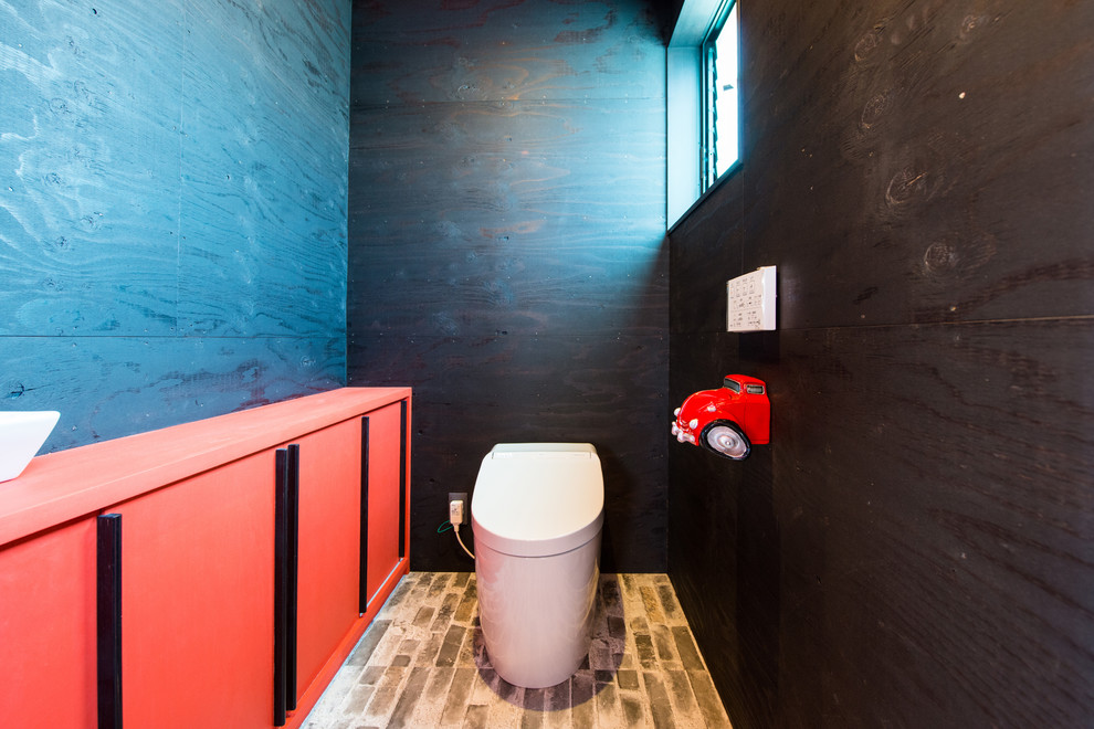 Inredning av ett industriellt toalett, med svarta väggar och brunt golv
