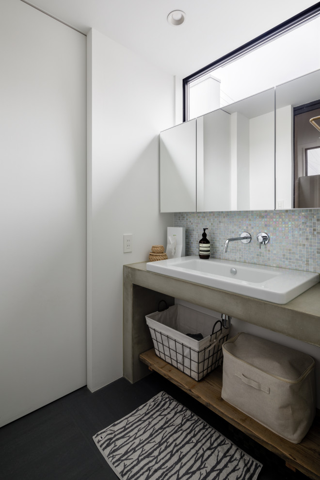 Пример оригинального дизайна: туалет в современном стиле с разноцветной плиткой, плиткой мозаикой, красными стенами, накладной раковиной, столешницей из бетона, черным полом и серой столешницей