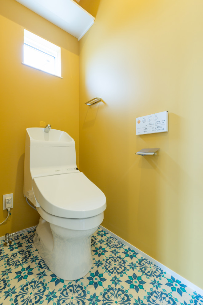Ispirazione per un bagno di servizio moderno di medie dimensioni con WC monopezzo, pareti gialle, pavimento in vinile e pavimento multicolore