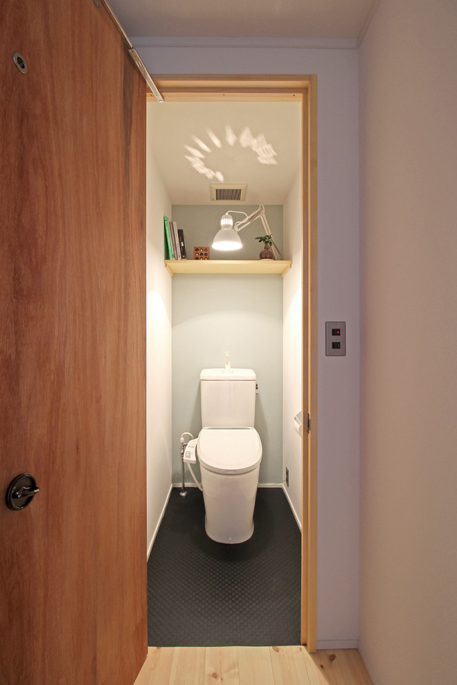 Inspiration för skandinaviska toaletter, med en toalettstol med hel cisternkåpa, blå väggar, vinylgolv och svart golv