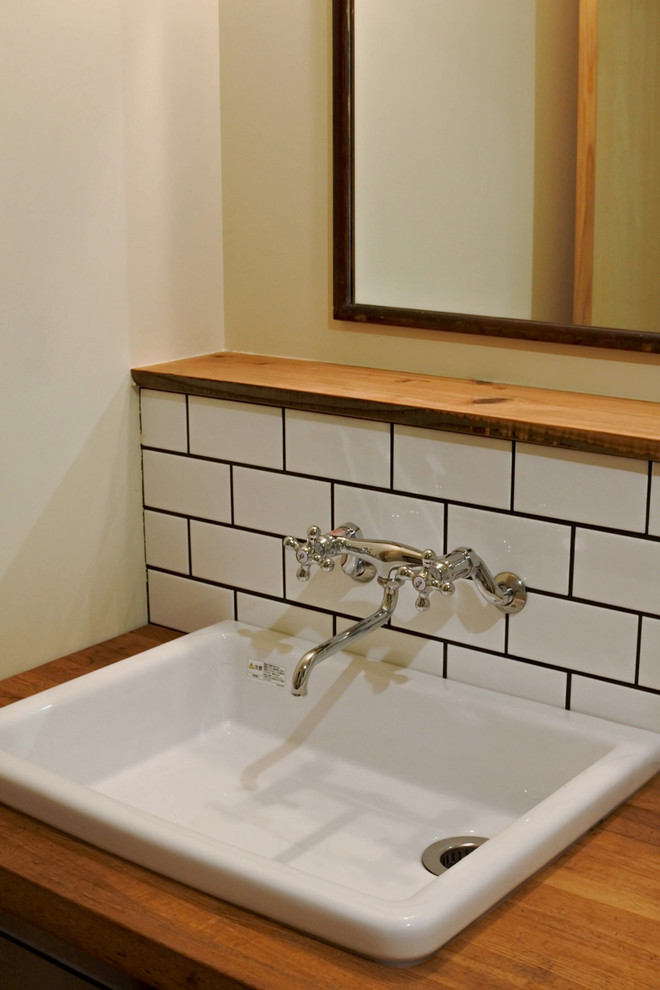 Idee per un piccolo bagno di servizio etnico con piastrelle bianche, piastrelle in gres porcellanato, pareti bianche, lavabo sottopiano, pavimento beige e top beige