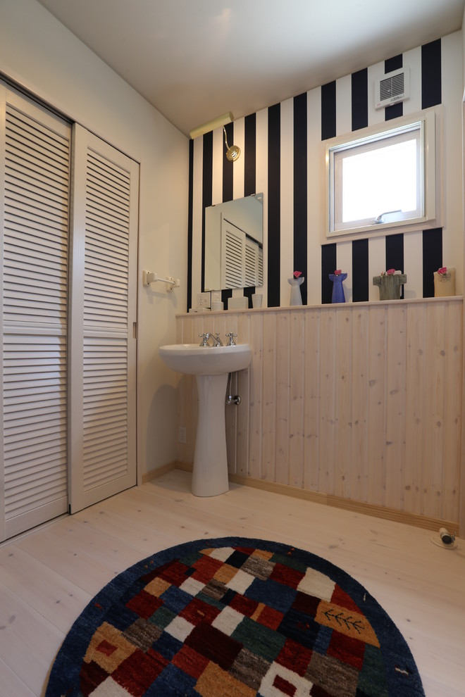 Идея дизайна: туалет в скандинавском стиле с белыми фасадами, разноцветными стенами, светлым паркетным полом, раковиной с пьедесталом и столешницей из дерева
