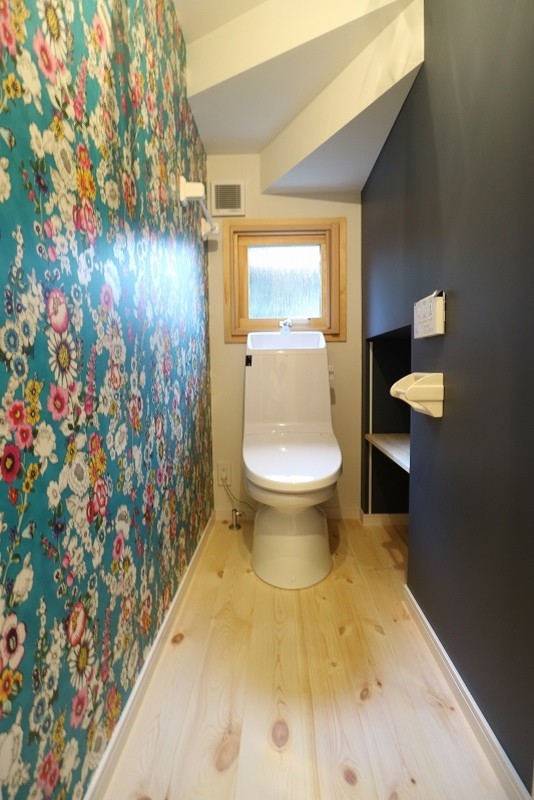 Example of a zen light wood floor powder room design in Other with open cabinets, black cabinets, multicolored walls and wood countertops