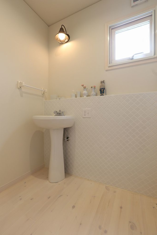 Свежая идея для дизайна: туалет в стиле кантри с белой плиткой, керамогранитной плиткой, белыми стенами, светлым паркетным полом и раковиной с пьедесталом - отличное фото интерьера