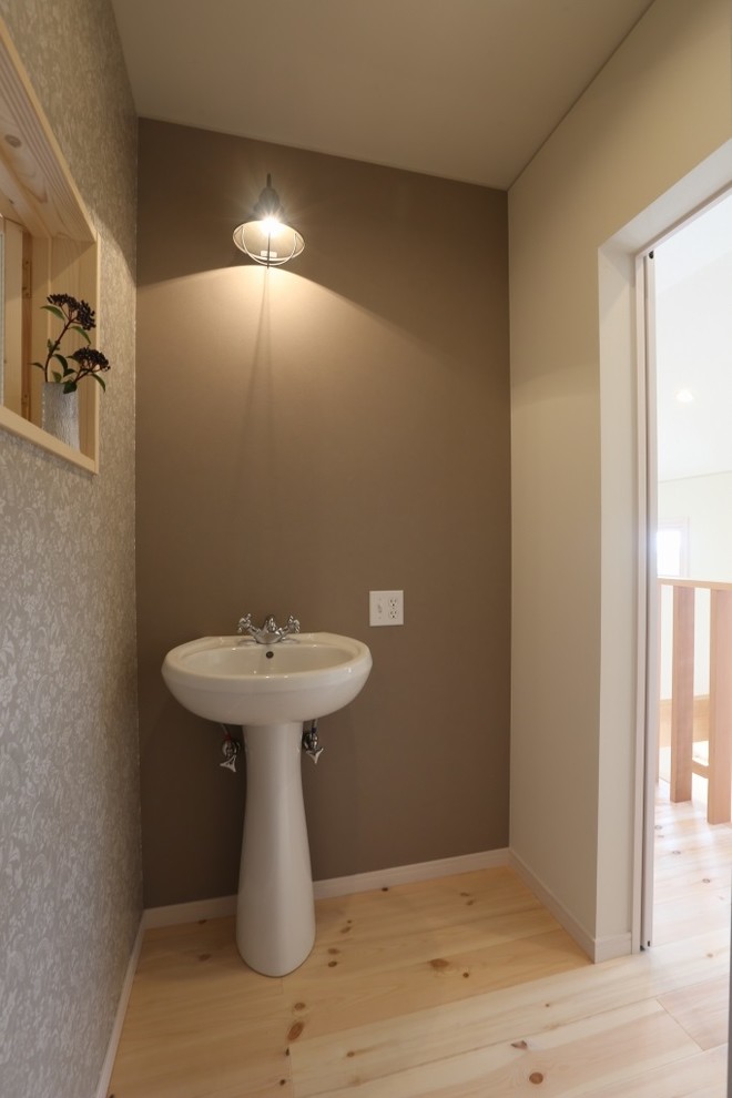 Shabby-Chic Gästetoilette mit beiger Wandfarbe, braunem Holzboden und Sockelwaschbecken in Sonstige