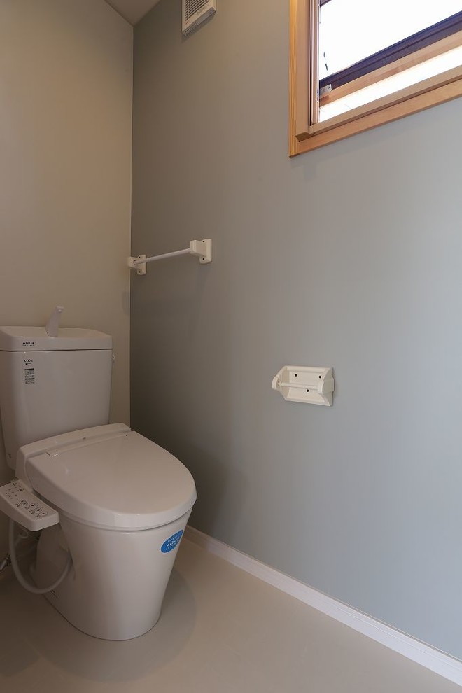 Idées déco pour un WC et toilettes asiatique avec un mur gris et un sol en linoléum.