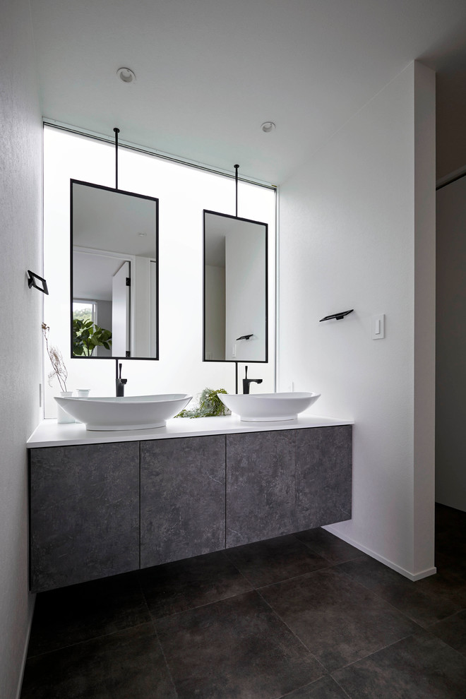 Inspiration för moderna toaletter, med släta luckor, grå skåp, vita väggar, ett fristående handfat och grått golv
