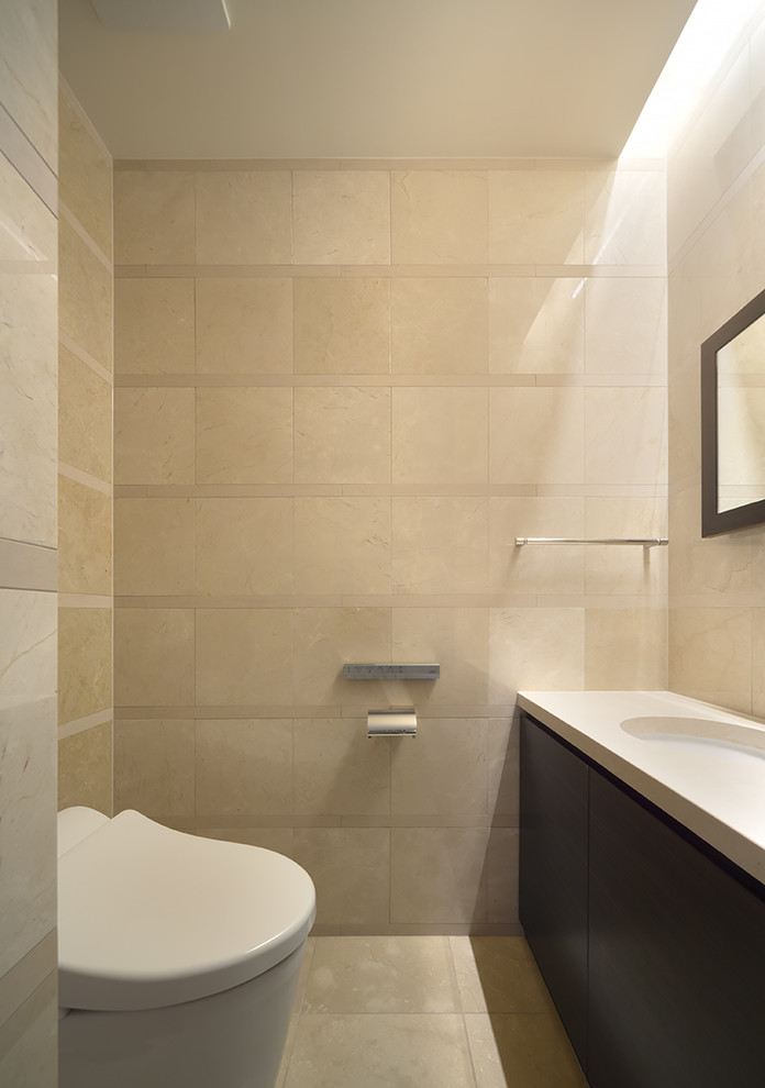Immagine di un piccolo bagno di servizio minimalista con ante in legno bruno, WC monopezzo, piastrelle beige, piastrelle di marmo, pareti beige, pavimento in marmo, lavabo sottopiano, top in marmo, pavimento beige e top beige