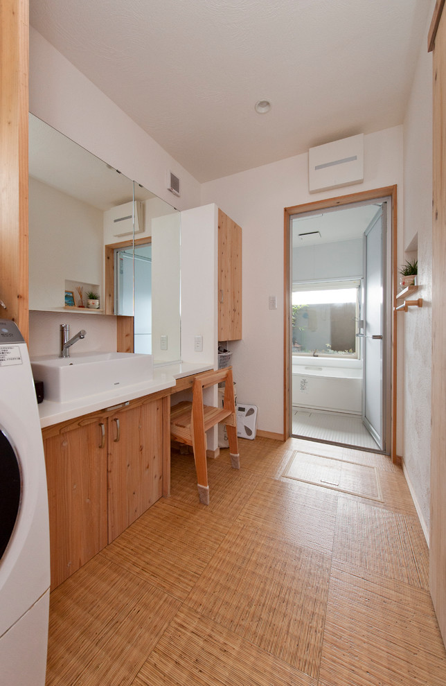 Esempio di un bagno di servizio etnico con ante lisce, ante marroni, pareti bianche, pavimento in vinile, lavabo a bacinella e pavimento marrone
