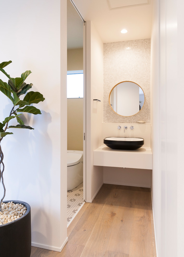 Пример оригинального дизайна: туалет в стиле модернизм с белыми стенами, светлым паркетным полом, настольной раковиной и бежевым полом