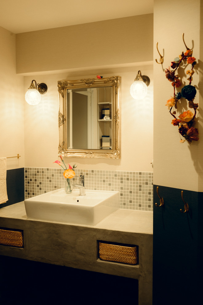 Esempio di un bagno di servizio contemporaneo con nessun'anta, piastrelle grigie, lavabo a bacinella, top in cemento, ante grigie, piastrelle a mosaico e pareti bianche