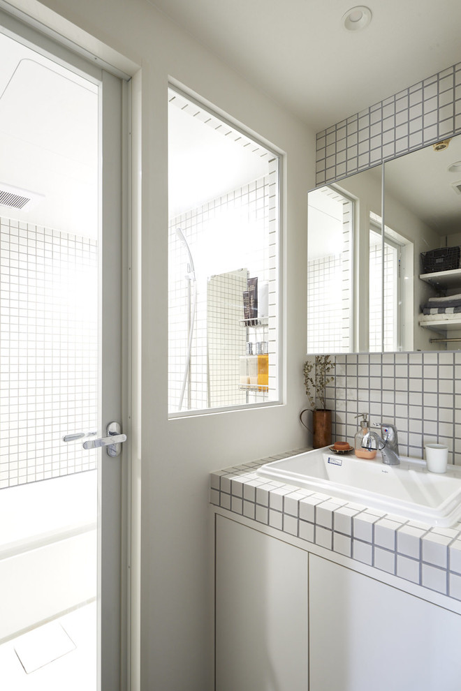 Стильный дизайн: туалет в стиле лофт с фасадами с декоративным кантом, белыми фасадами, белой плиткой, керамогранитной плиткой, белыми стенами, столешницей из плитки и белой столешницей - последний тренд