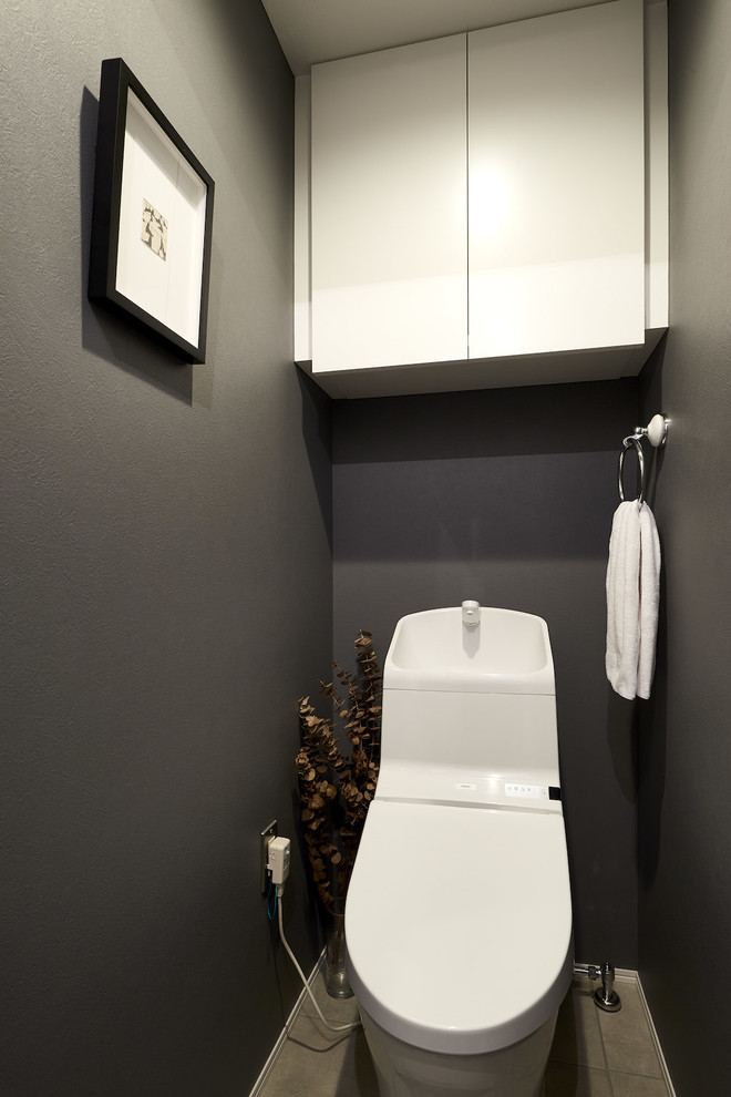 Inredning av ett industriellt toalett, med svarta väggar, vinylgolv och grått golv