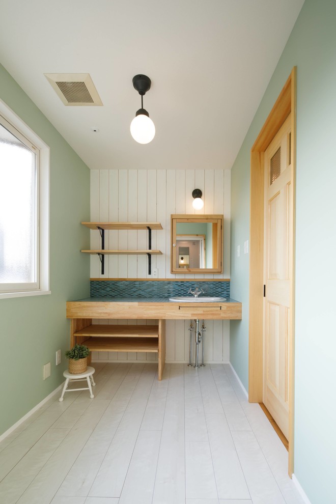 他の地域にある北欧スタイルのおしゃれなトイレ・洗面所 (オープンシェルフ、青い壁、塗装フローリング、オーバーカウンターシンク、白い床) の写真