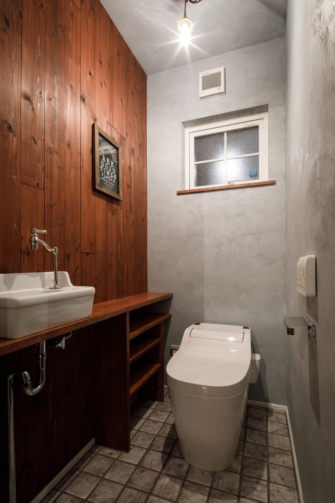 Idee per un bagno di servizio industriale con nessun'anta, ante in legno scuro, pareti multicolore, lavabo a bacinella, top in legno, pavimento grigio e top marrone