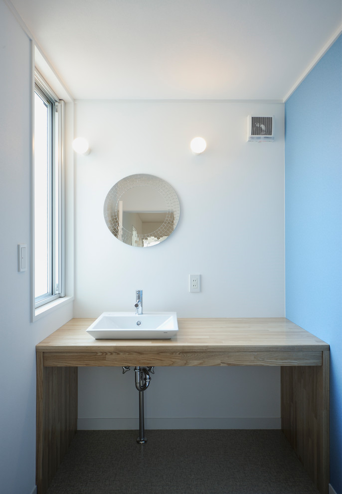 Idee per un bagno di servizio moderno di medie dimensioni con WC monopezzo, piastrelle bianche, pareti multicolore, pavimento in vinile, lavabo a bacinella, top in legno, pavimento beige e top beige