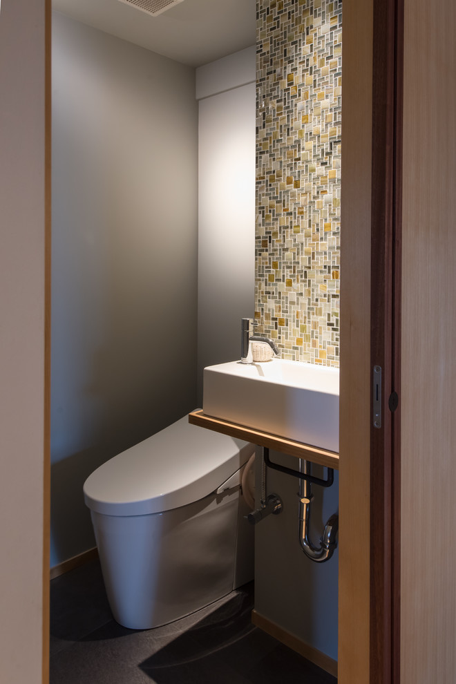 Idee per un bagno di servizio minimal con pareti grigie, lavabo a bacinella e pavimento grigio