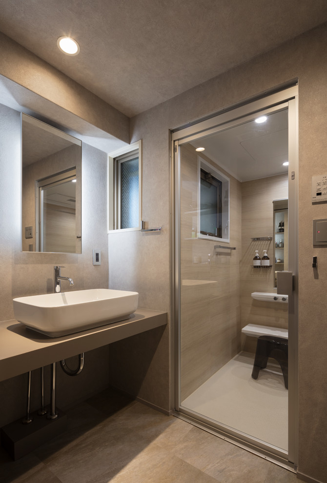Aménagement d'un WC et toilettes industriel avec un mur gris, une vasque, un plan de toilette en béton, un sol gris et un plan de toilette gris.