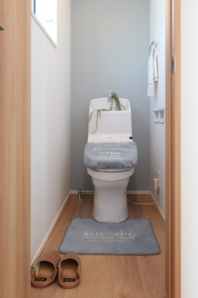 Inspiration för små maritima toaletter, med flerfärgade väggar, ljust trägolv och beiget golv