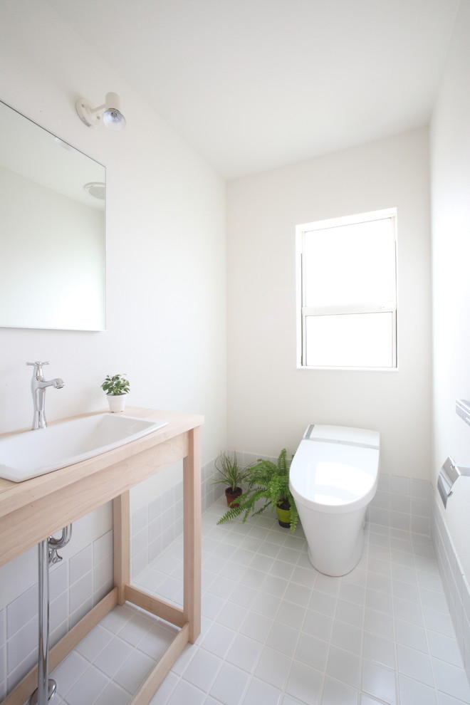 На фото: туалет среднего размера в скандинавском стиле с белыми стенами, светлым паркетным полом и бежевым полом с