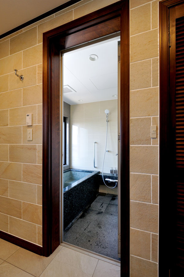 Стильный дизайн: туалет среднего размера в стиле модернизм с плоскими фасадами, коричневыми фасадами, бежевой плиткой, керамогранитной плиткой, бежевыми стенами, полом из керамогранита, настольной раковиной, столешницей из плитки, черным полом, черной столешницей и встроенной тумбой - последний тренд