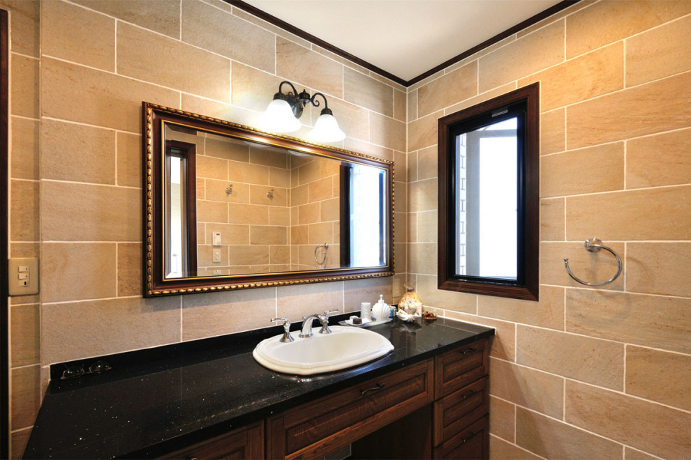 Inspiration för mellanstora moderna svart toaletter, med släta luckor, bruna skåp, beige kakel, porslinskakel, beige väggar, klinkergolv i porslin, ett fristående handfat, kaklad bänkskiva och svart golv