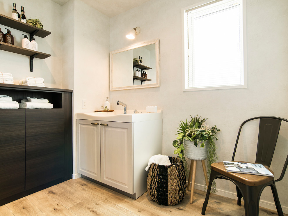 Inspiration for a bohemian cloakroom in Other with raised-panel cabinets, grey cabinets, white walls, an integrated sink, brown floors and plywood flooring.