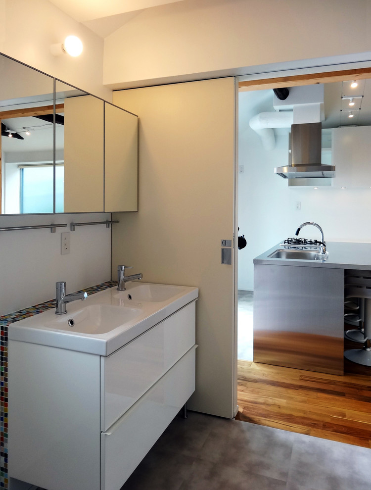 Inspiration for a medium sized modern cloakroom in Tokyo with flat-panel cabinets, white cabinets, white tiles, white walls, vinyl flooring, an integrated sink, grey floors and white worktops.