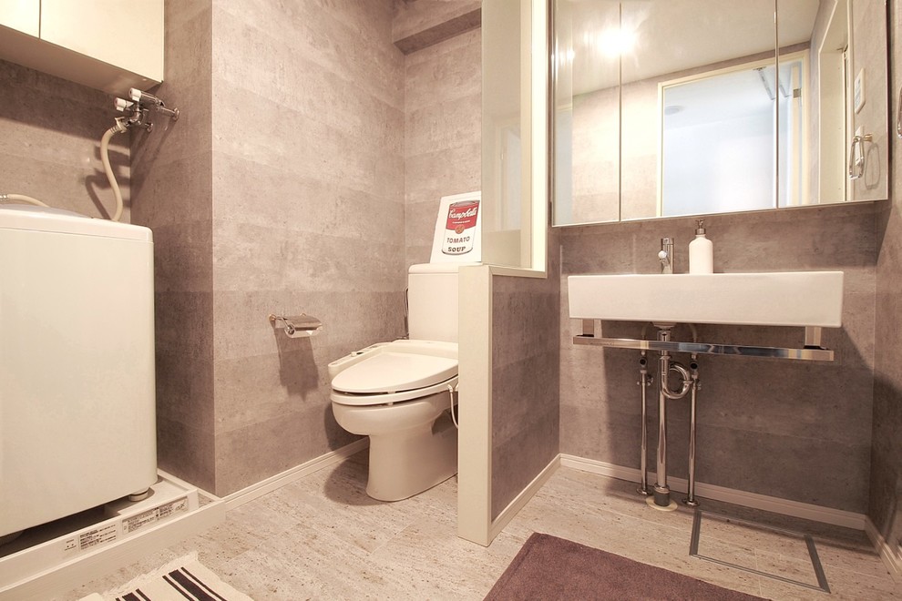 Immagine di un bagno di servizio industriale con pareti grigie, lavabo a consolle e pavimento grigio
