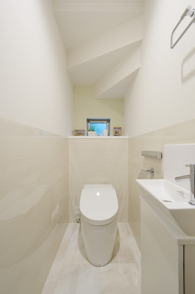Aménagement d'un WC et toilettes moderne avec un mur blanc, un sol en linoléum et un sol blanc.