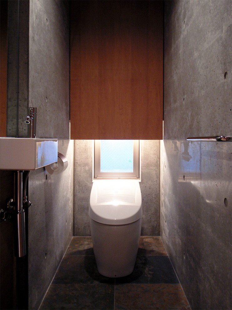 Idée de décoration pour un WC et toilettes minimaliste en bois foncé avec un placard à porte plane, un carrelage multicolore, un carrelage de pierre, un mur gris, un sol en ardoise, un lavabo suspendu et un plan de toilette en surface solide.