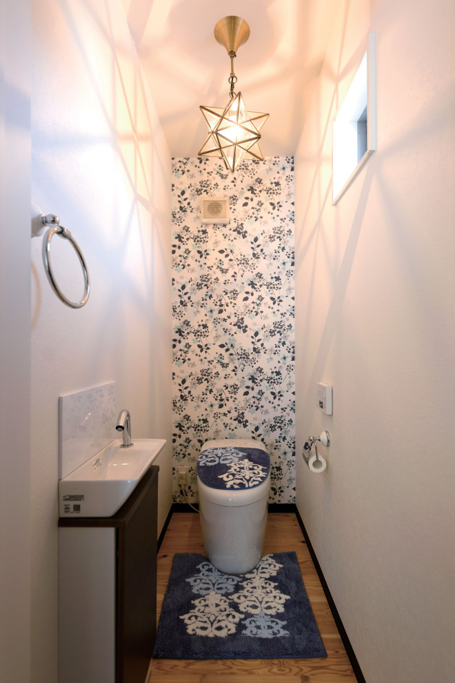 Ispirazione per un bagno di servizio minimalista con WC monopezzo, pareti bianche, parquet chiaro, soffitto in carta da parati e carta da parati