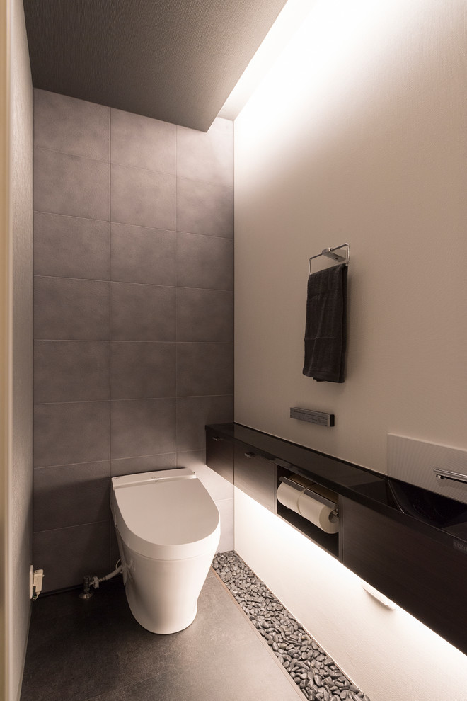 Inspiration för ett mellanstort funkis toalett, med svarta skåp, porslinskakel, klinkergolv i porslin, träbänkskiva och grå kakel