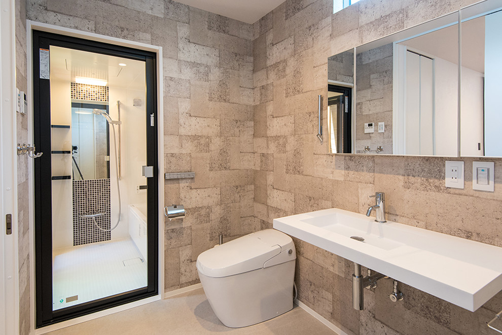 Inspiration pour un WC suspendu chalet de taille moyenne avec un placard à porte plane, des portes de placard blanches, un carrelage gris, un mur gris, un sol en vinyl et un sol beige.