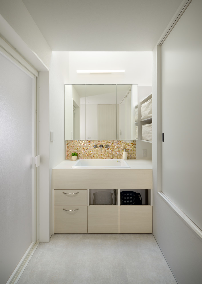 Пример оригинального дизайна: туалет в стиле модернизм с плоскими фасадами, бежевыми фасадами, белыми стенами, накладной раковиной и серым полом