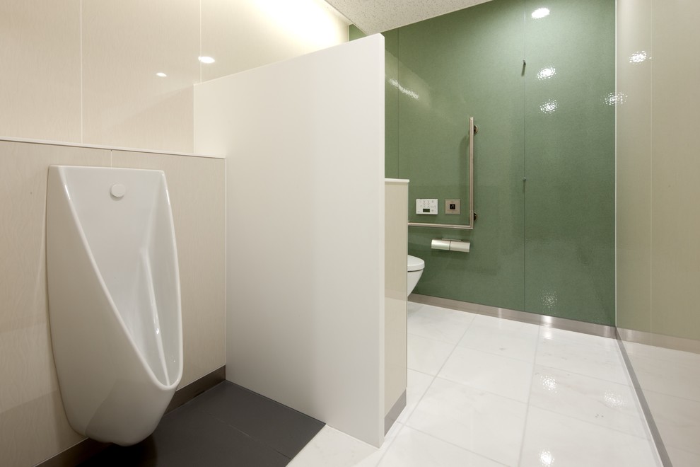 На фото: маленький туалет в стиле модернизм с светлыми деревянными фасадами, раздельным унитазом, зелеными стенами, мраморным полом, настольной раковиной и белым полом для на участке и в саду