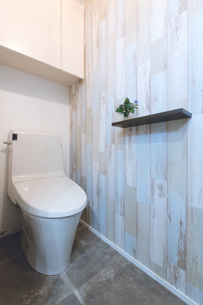 札幌にある中くらいな北欧スタイルのおしゃれなトイレ・洗面所 (フラットパネル扉のキャビネット、白いキャビネット、一体型トイレ	、マルチカラーの壁、セラミックタイルの床) の写真