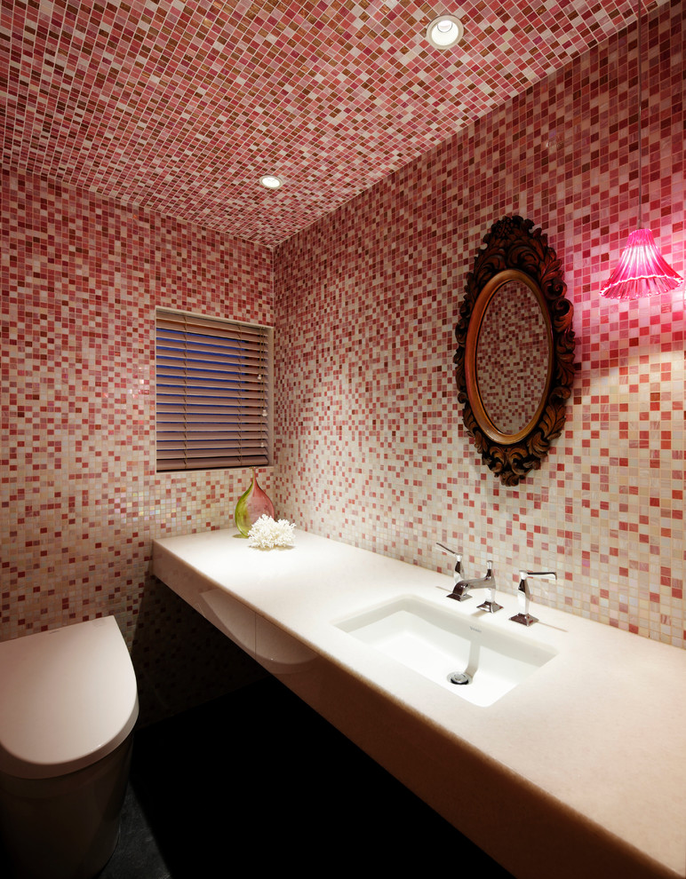 東京23区にあるコンテンポラリースタイルのおしゃれなトイレ・洗面所 (モザイクタイル、ピンクのタイル、赤い壁、アンダーカウンター洗面器、壁掛け式トイレ) の写真
