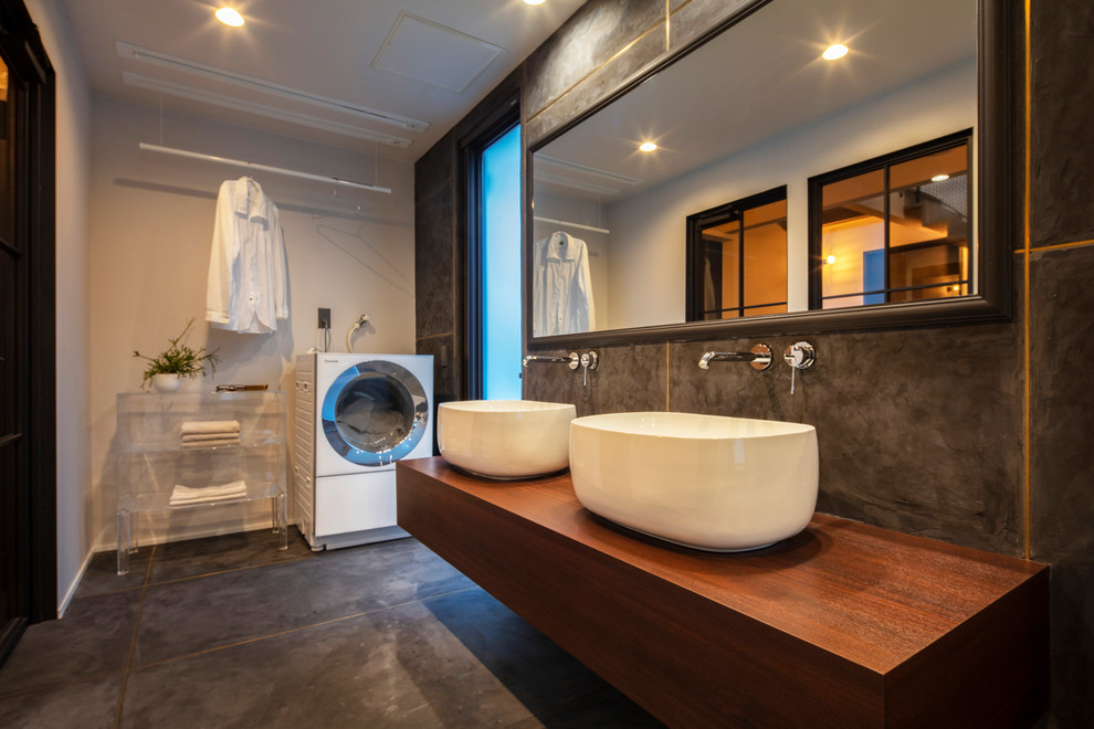 Moderne Gästetoilette mit Aufsatzwaschbecken und grauem Boden in Sonstige