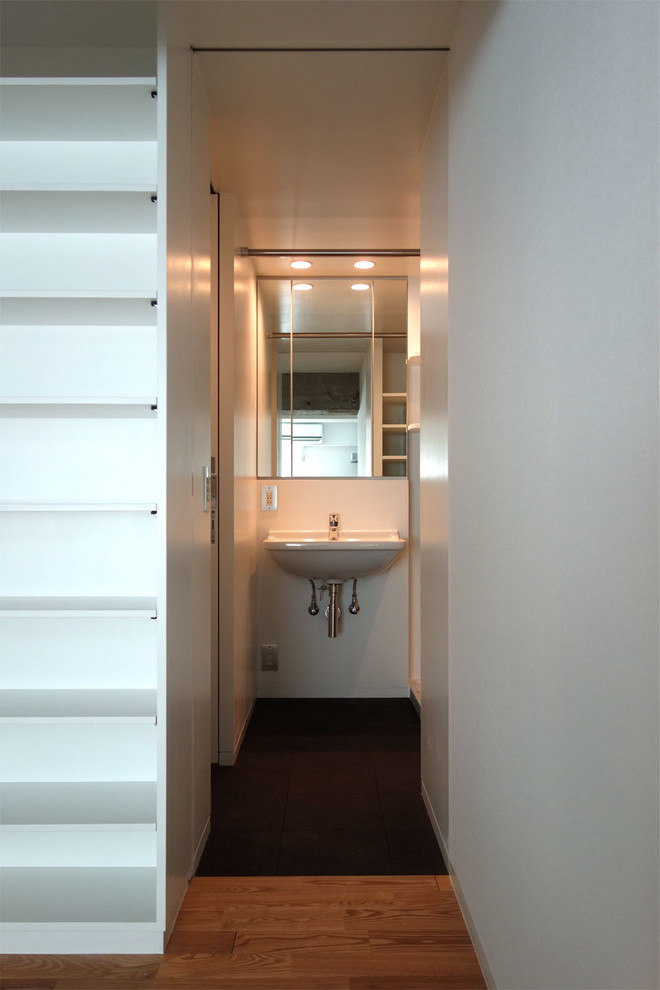 Immagine di un bagno di servizio moderno con pareti bianche e lavabo sospeso
