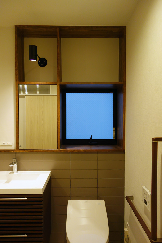 東京23区にあるモダンスタイルのおしゃれなトイレ・洗面所 (濃色木目調キャビネット、一体型トイレ	、グレーのタイル、磁器タイル、クッションフロア) の写真