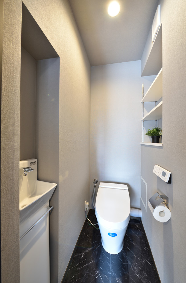 Kleine Moderne Gästetoilette mit offenen Schränken, weißen Schränken, Toilette mit Aufsatzspülkasten, grauen Fliesen, grauer Wandfarbe, Vinylboden, Mineralwerkstoff-Waschtisch, schwarzem Boden und weißer Waschtischplatte in Sonstige