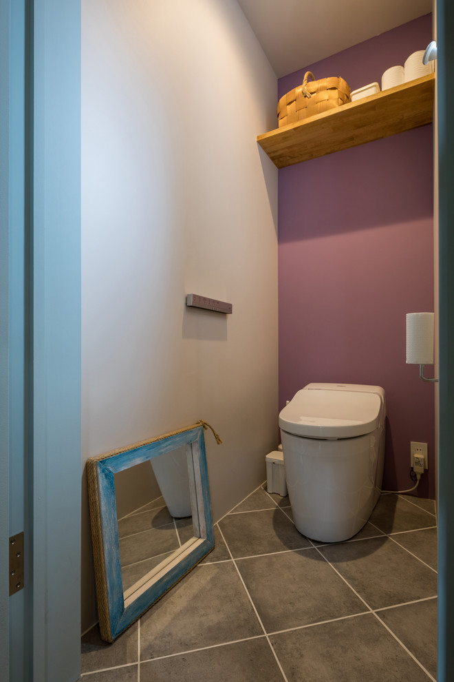 Стильный дизайн: туалет в современном стиле с фиолетовыми стенами, полом из терракотовой плитки и серым полом - последний тренд